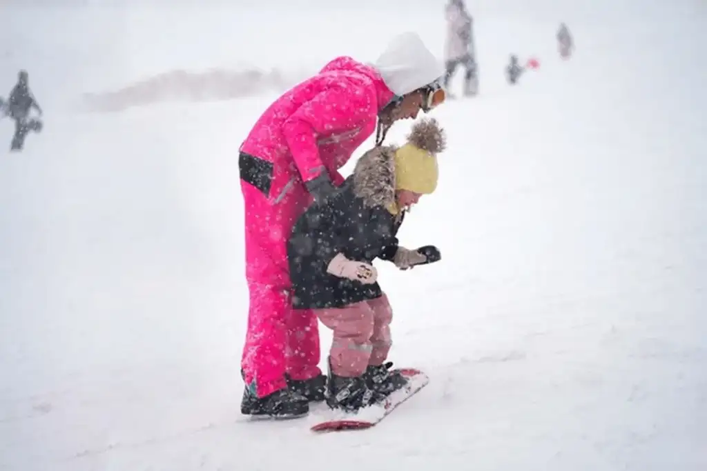 Erciyes Kayak Merkezi pistlerinde snowboard ekipmanları ve kaskı ile eğitime hazırlanan çocuk.